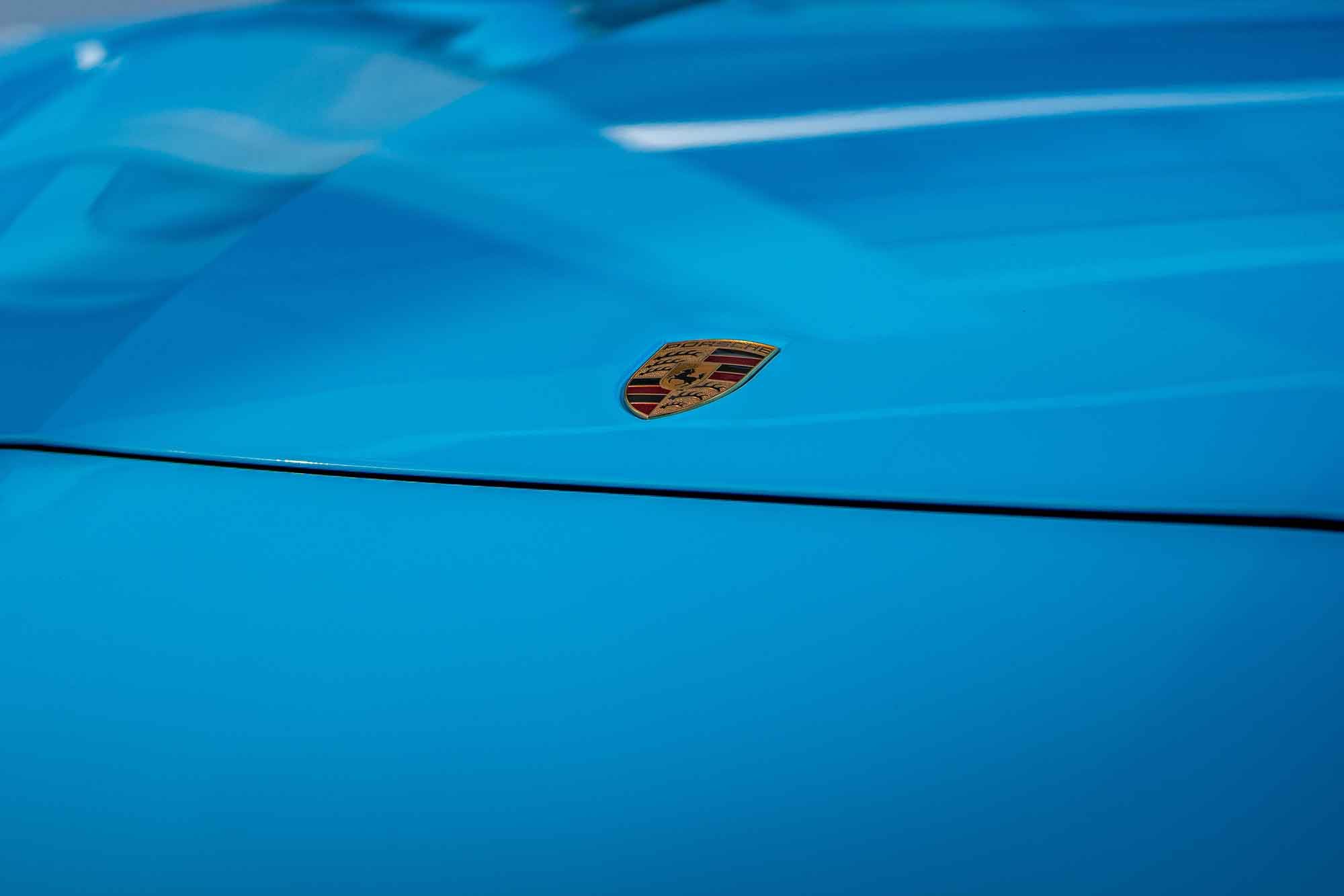 Porsche crest on a blue bonnet