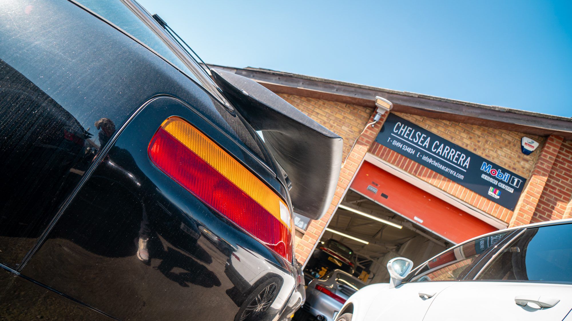 Chelsea Carrera's workshop, with a Porsche 911 tail light in the foreground