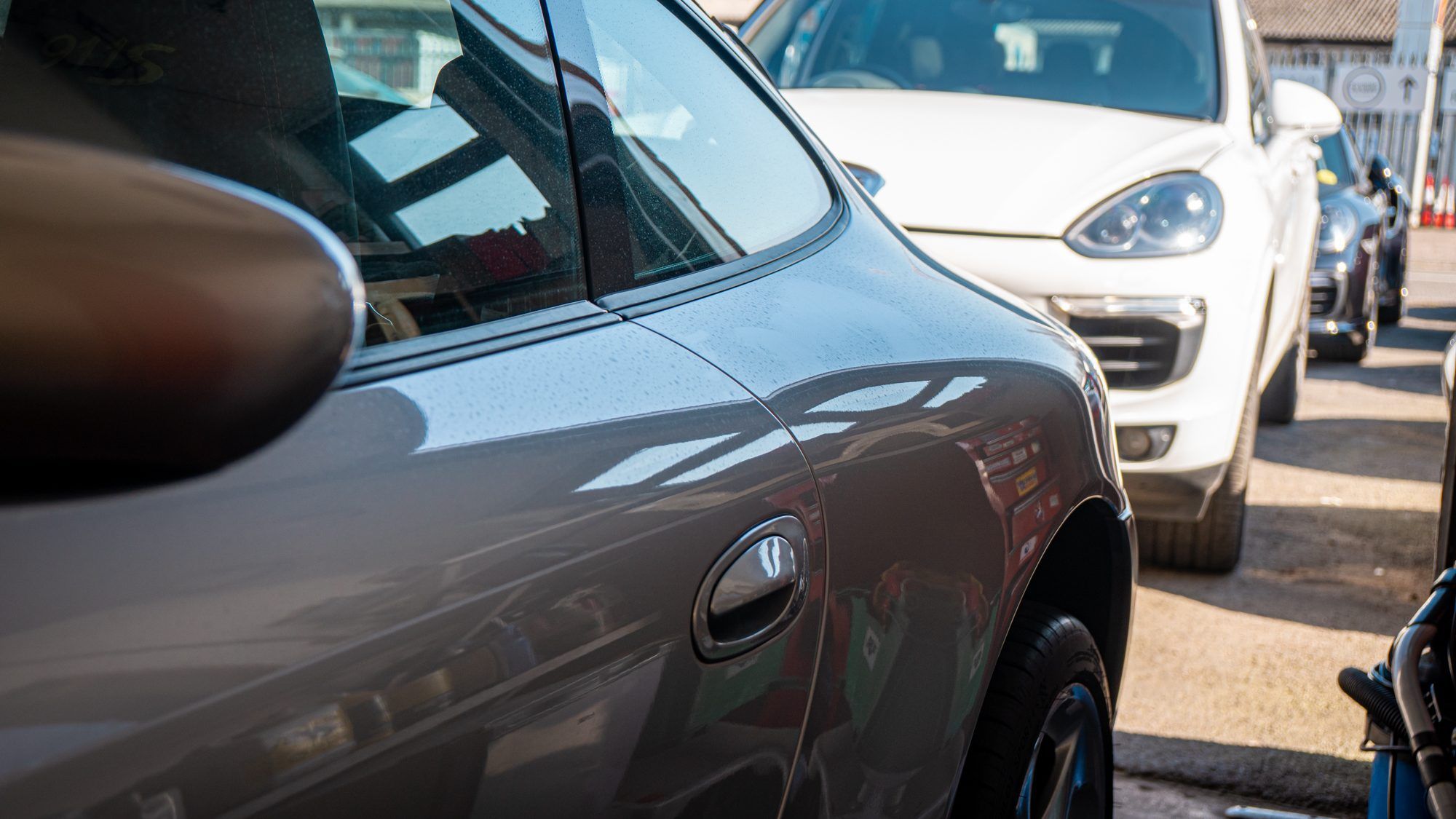 Grey Porsche 911 and a white Cayenne at the workshop