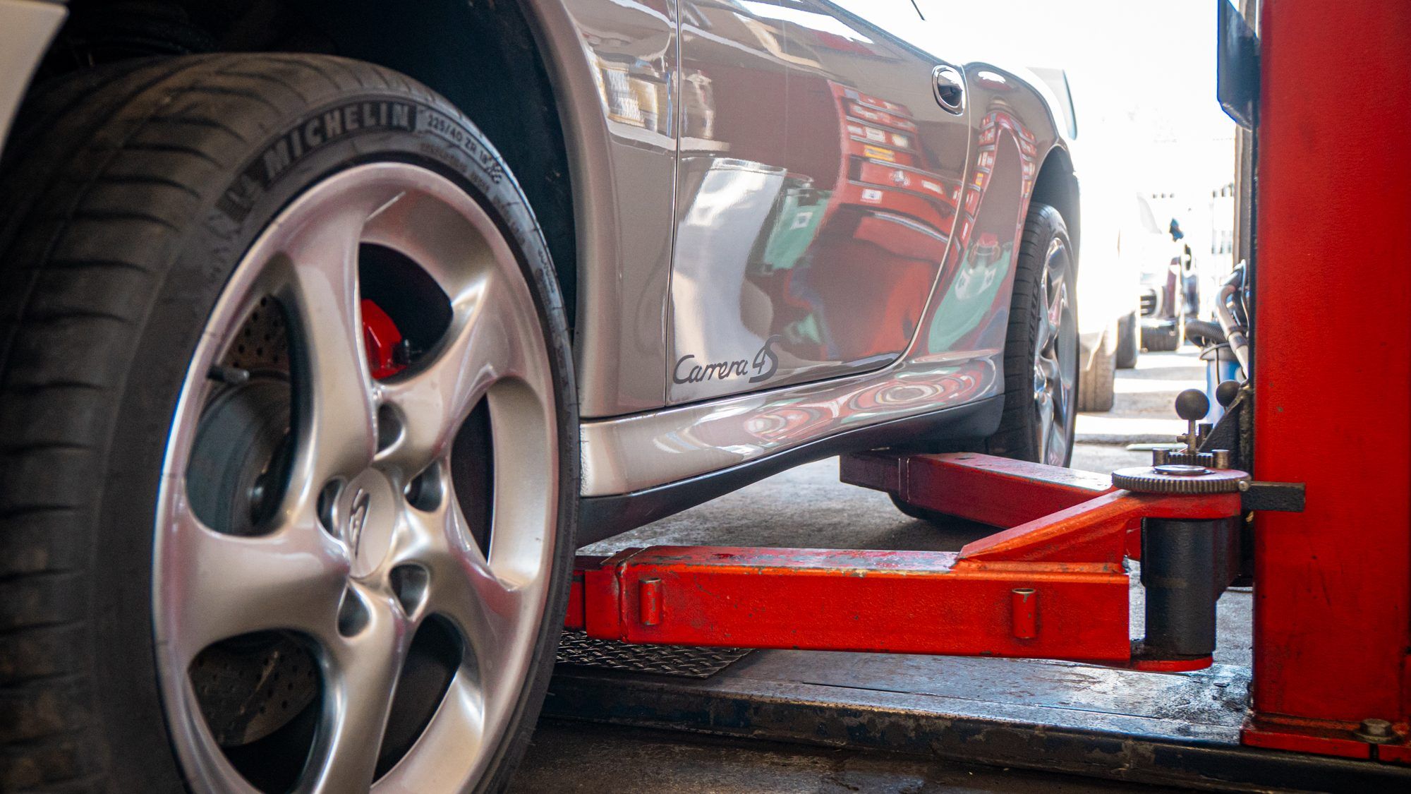 Porsche 911 Carrera S wheel above a lift arm