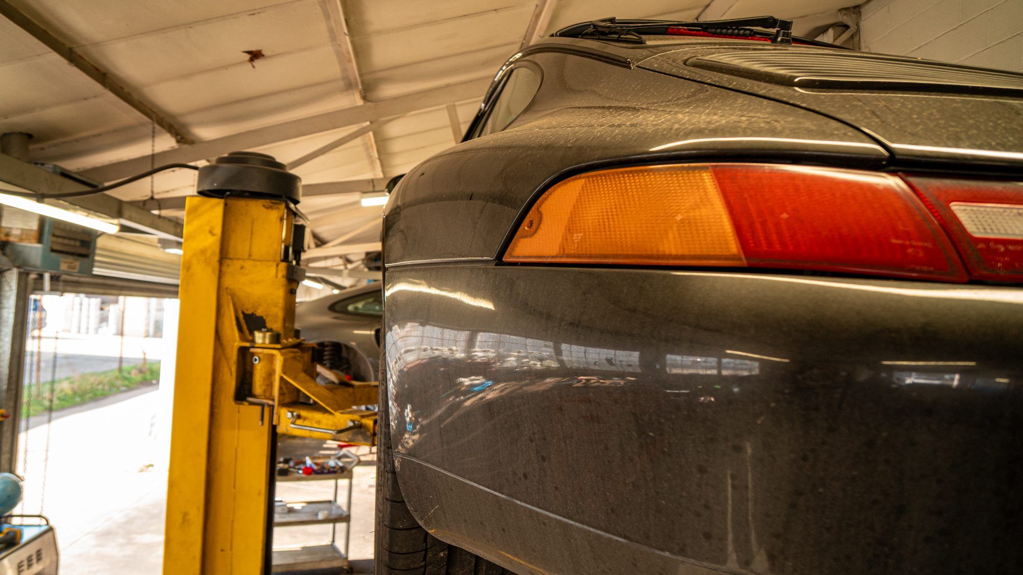 Rear of a grey Porsche 911 on a workshop lift