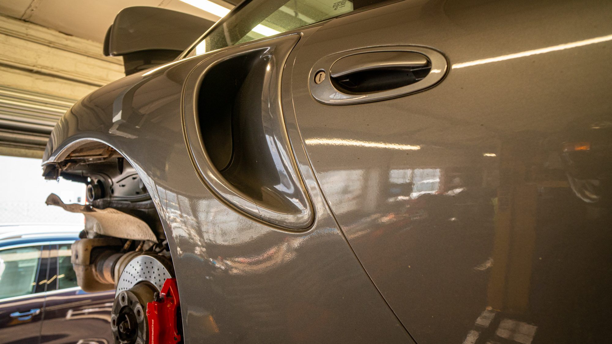 Side air intake of a grey Porsche 911 Turbo in the workshop