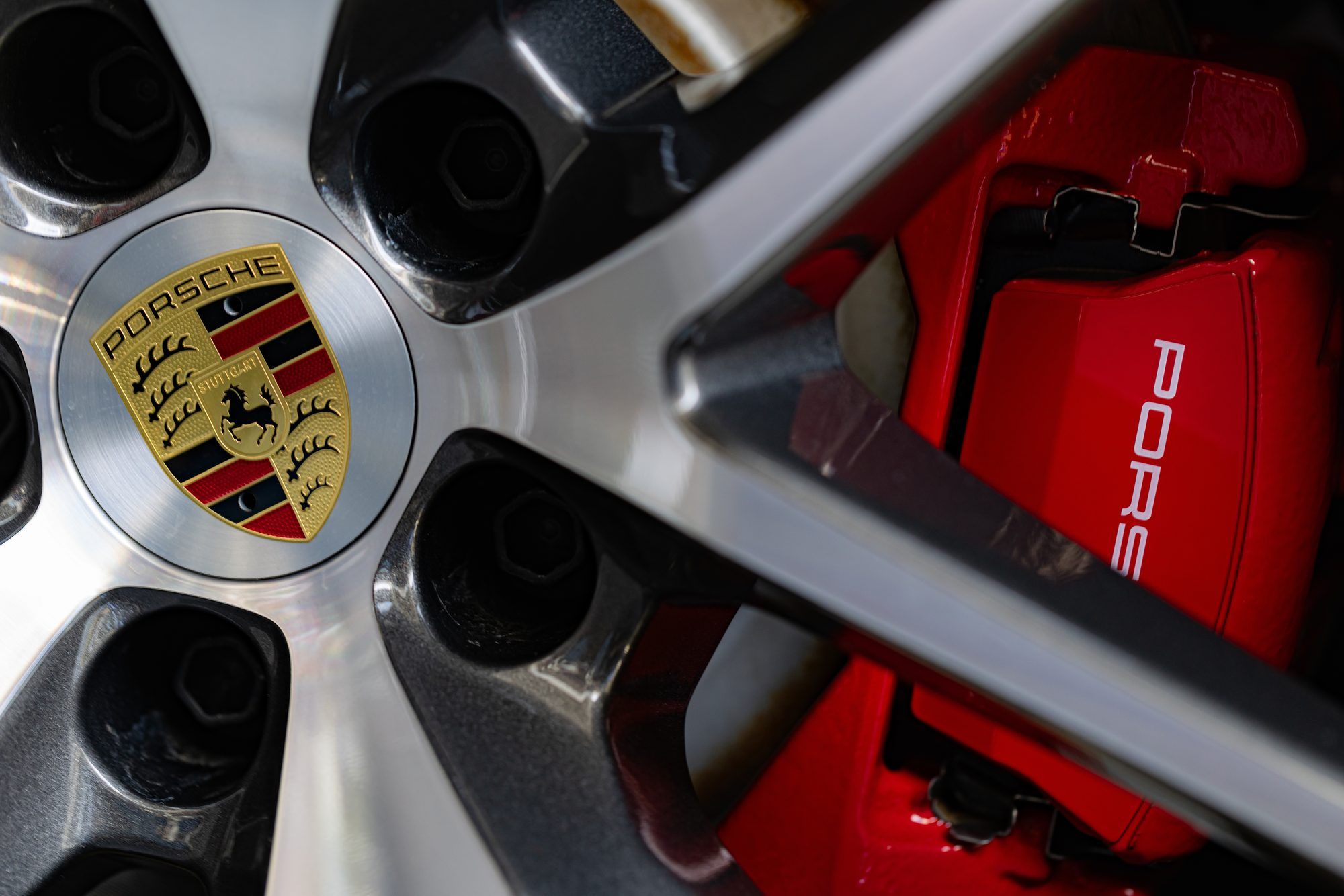 Porsche alloy wheel with a red brake caliper behind it