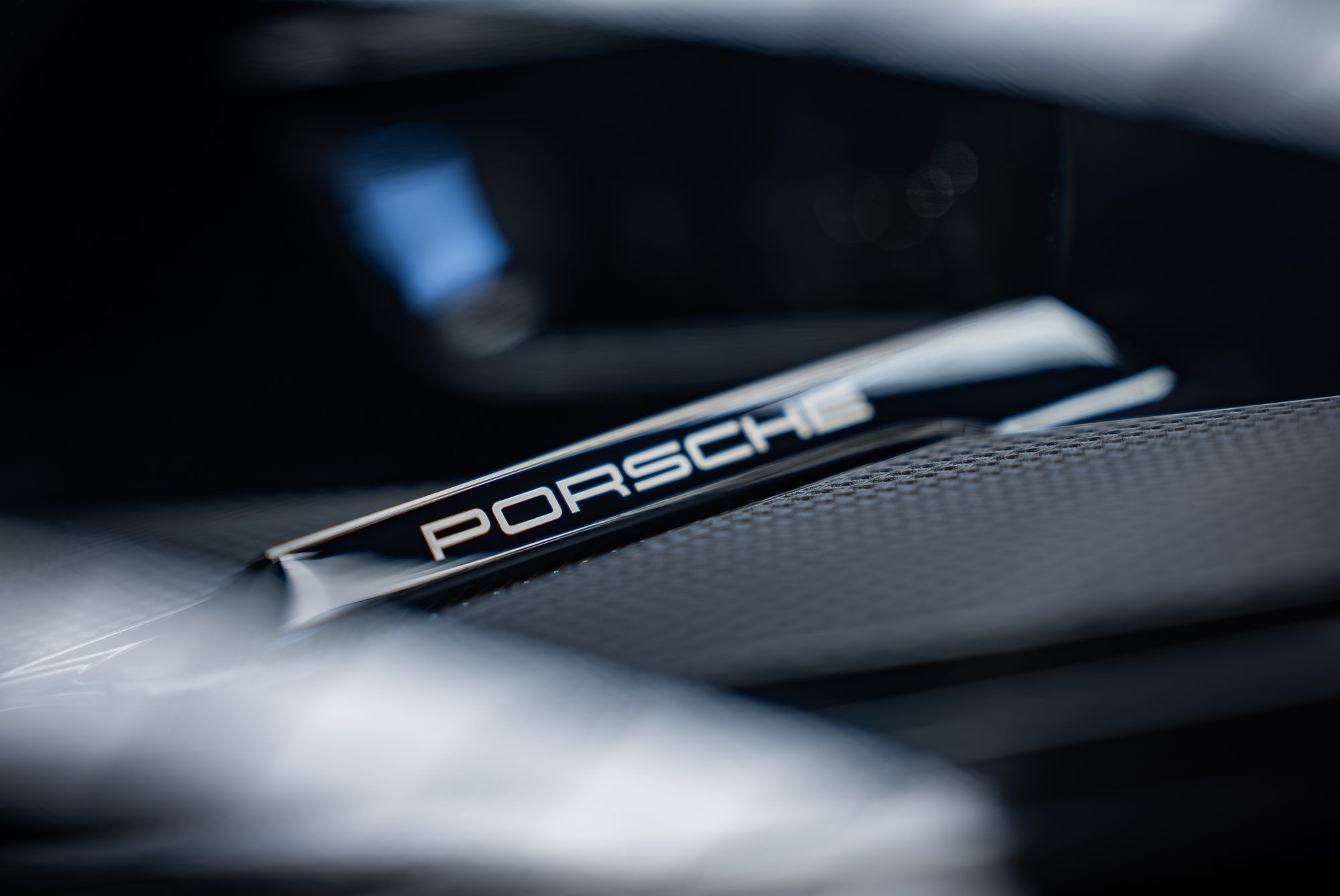 Porsche lettering on the interior trim, with a dashboard screen behind