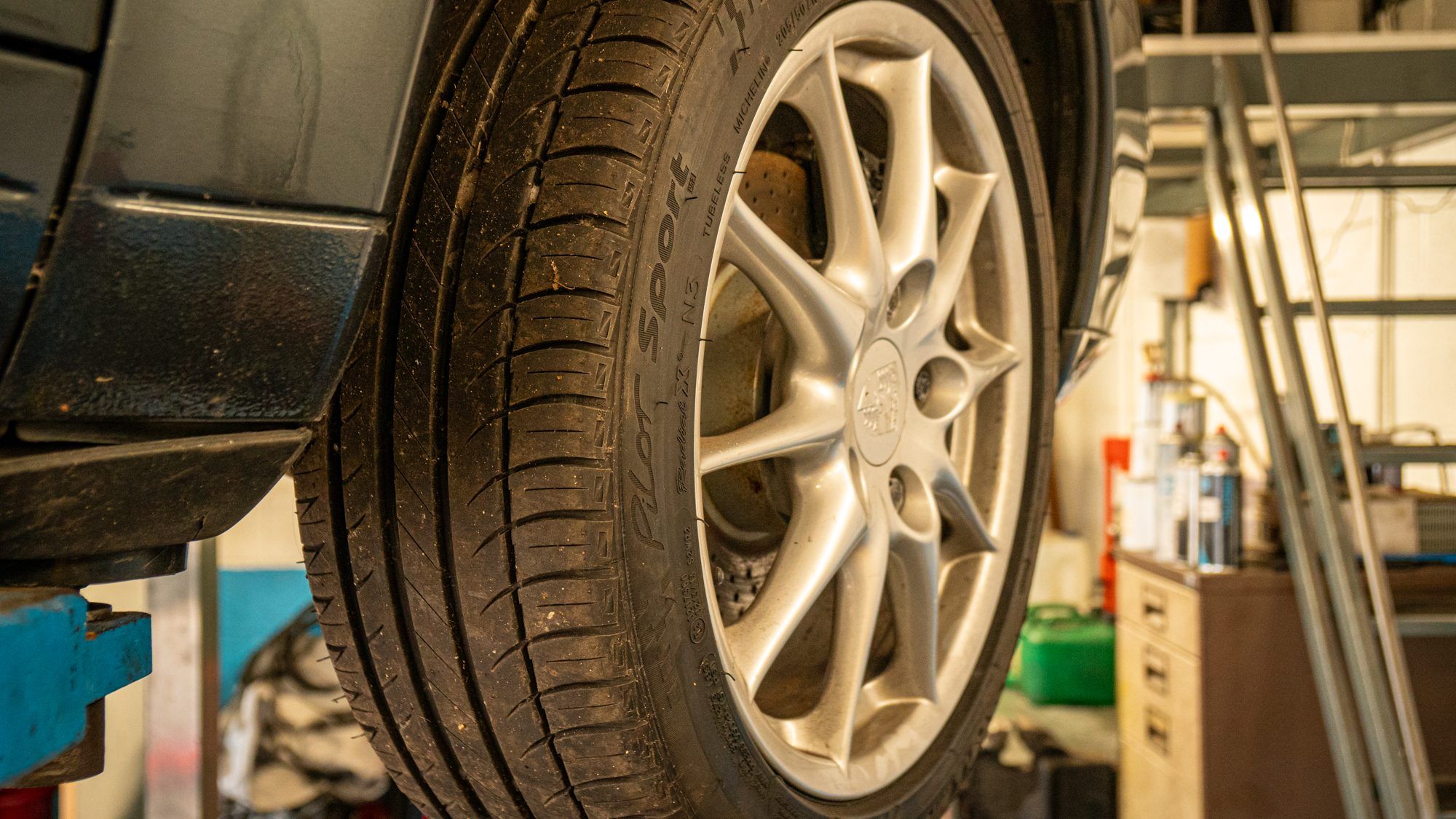Porsche wheel and tyre with the car raised on a lift