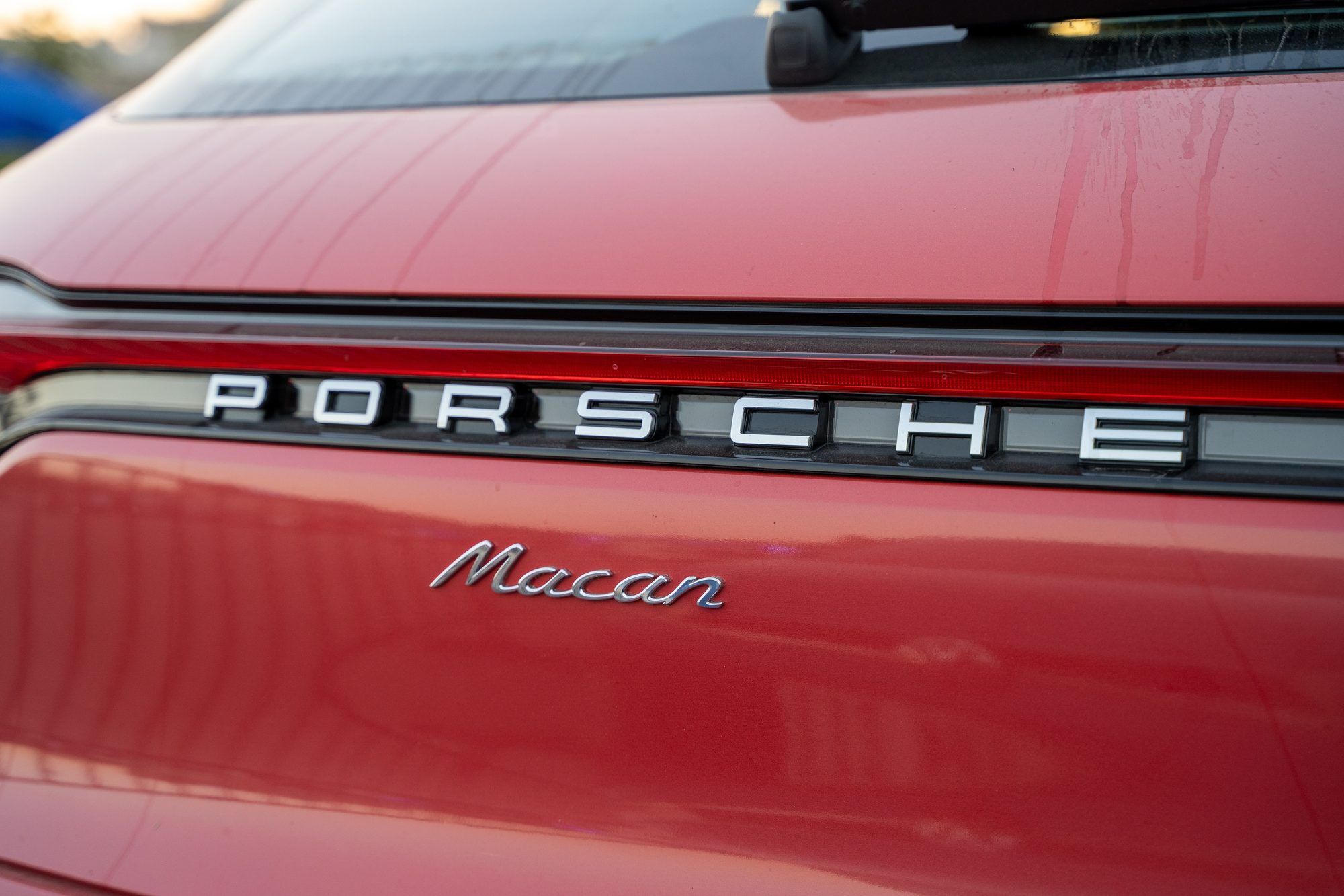 Porsche and Macan lettering on the tailgate of a red Macan