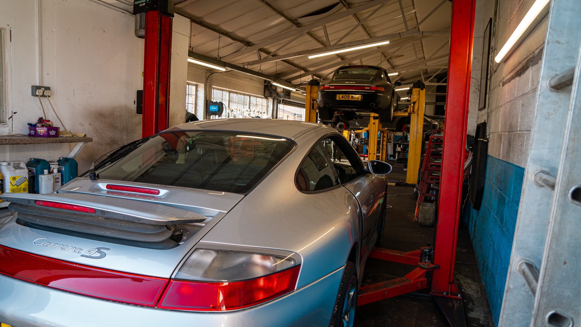 Silver Porsche 911 on a lift in the workshop
